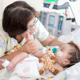 nurse tending to baby patient in bed
